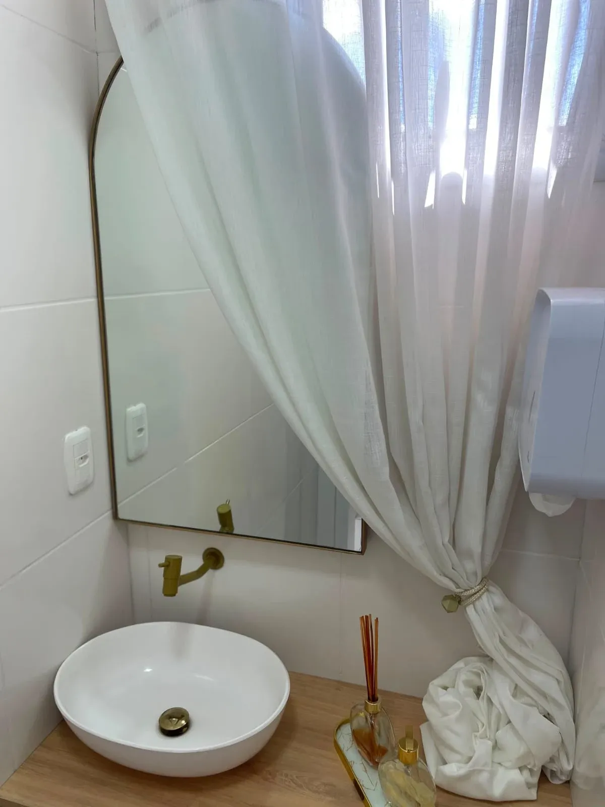 Lavabo com espelho de moldura metálica e detalhes em bronze sob medida — projeto residencial Schreiner